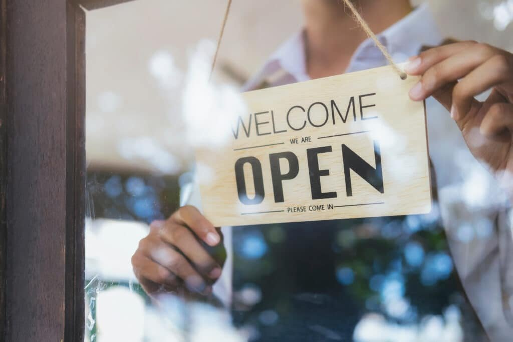 Small business owner welcoming a customer at their storefront