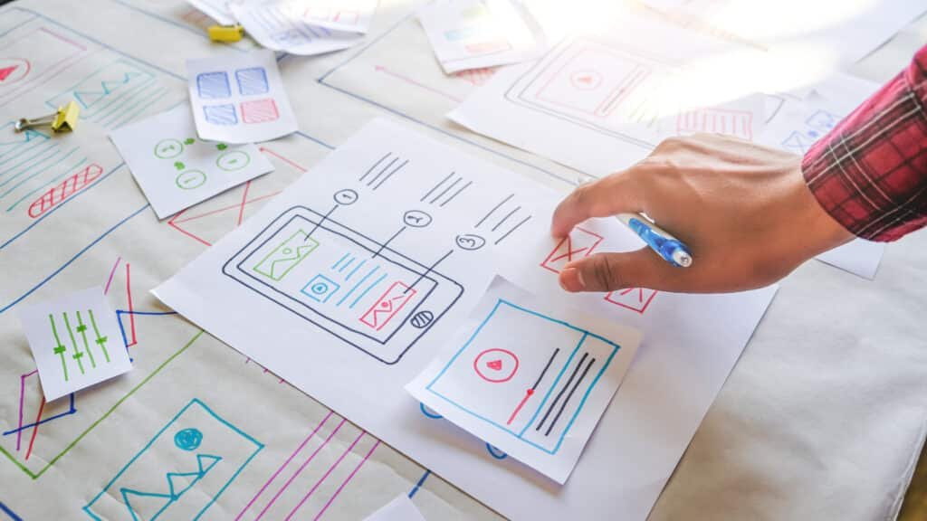 UI/UX designer sketching a navigation menu wireframe on paper