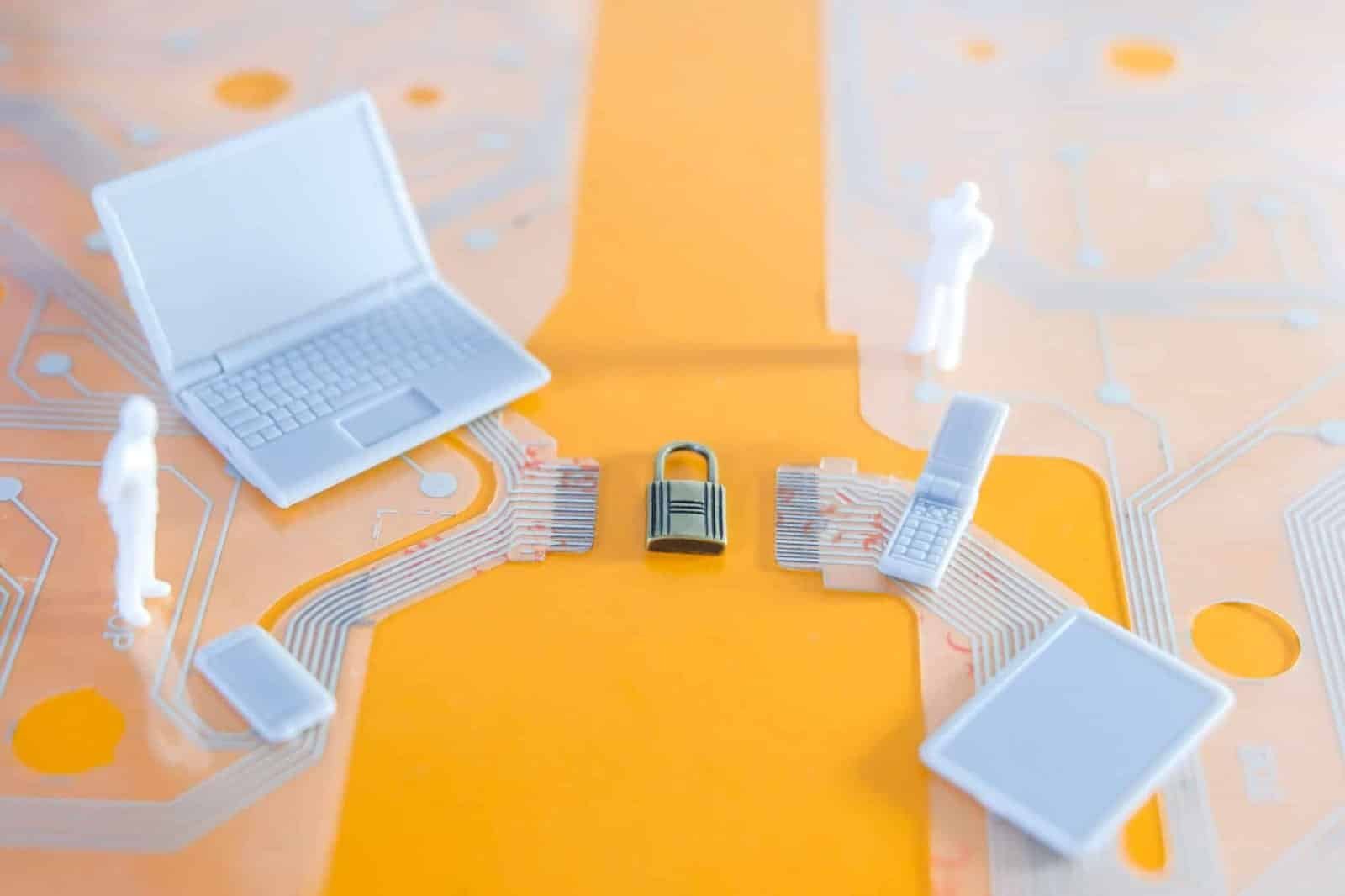 A laptop alongside a padlock on a circuit board, representing the importance of securing digital information.