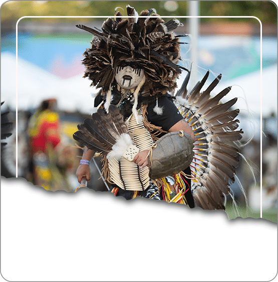A traditional dancer in feathered regalia performing at an Oneida Nation Pow Wow